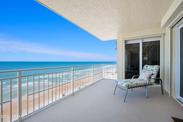 balcony featuring a beach view and a water view