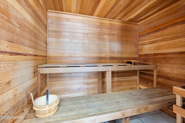 view of sauna featuring wooden ceiling, tile patterned flooring, and wooden walls