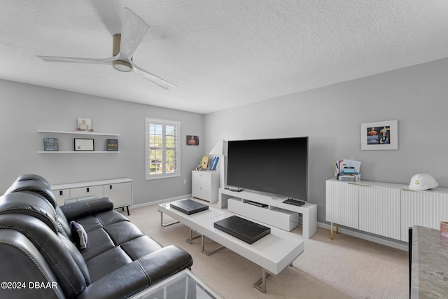 living room with ceiling fan, a textured ceiling, and light colored carpet