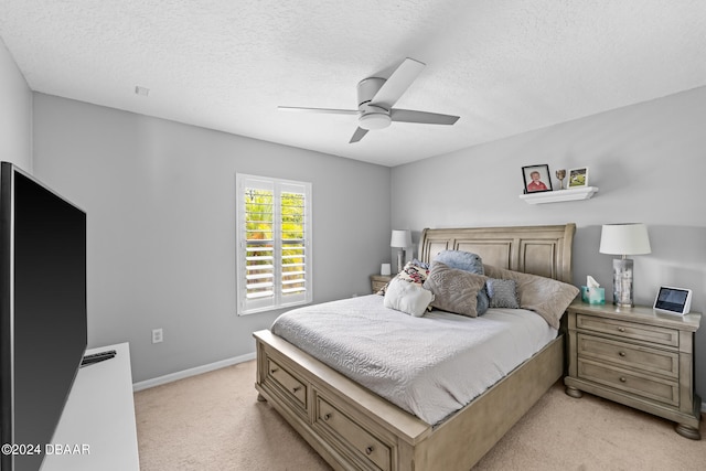 carpeted bedroom with ceiling fan and a textured ceiling