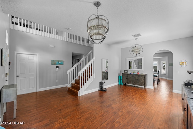 foyer featuring a chandelier, a textured ceiling, and dark hardwood / wood-style flooring