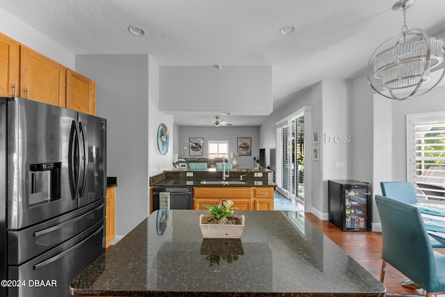 kitchen featuring hardwood / wood-style floors, stainless steel fridge, black dishwasher, and a center island