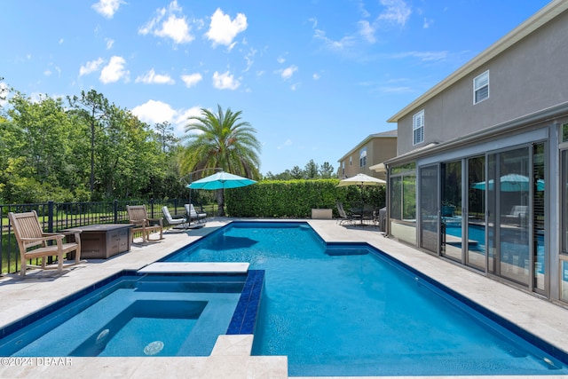 view of pool with a patio and an in ground hot tub