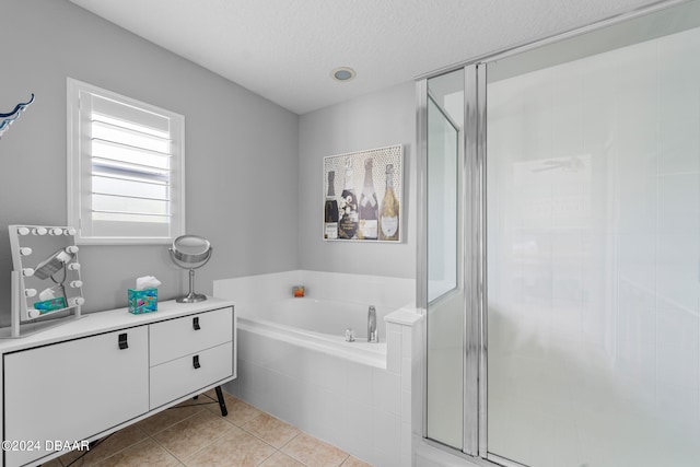 bathroom featuring tile patterned floors, separate shower and tub, and a textured ceiling