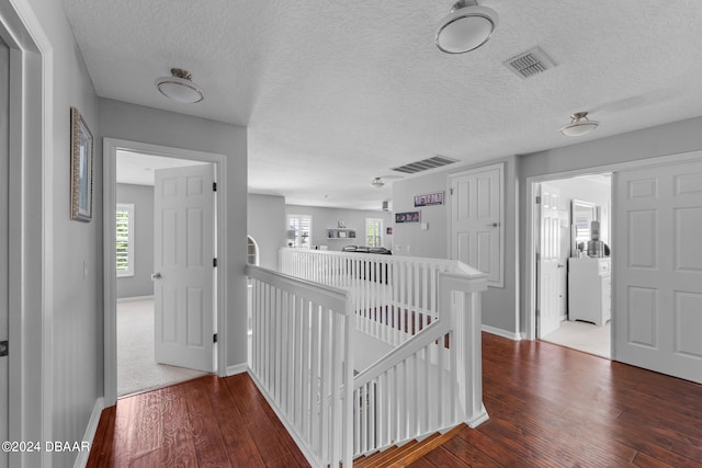 hallway featuring a textured ceiling and hardwood / wood-style flooring