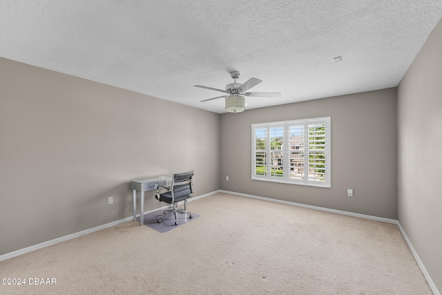 unfurnished office featuring ceiling fan, a textured ceiling, and light carpet