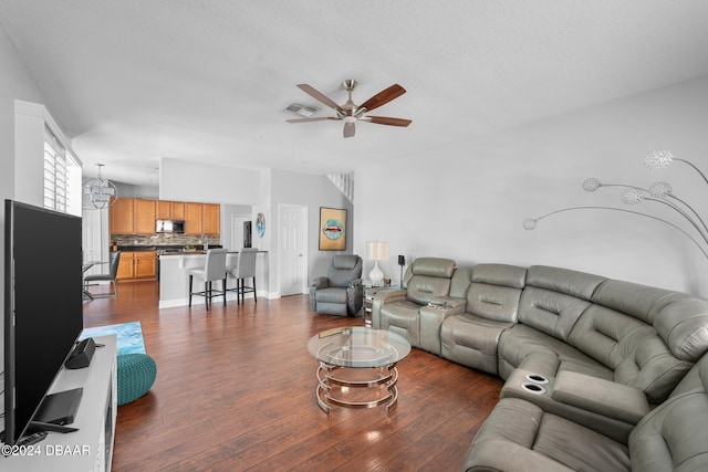 living room featuring dark wood-type flooring and ceiling fan with notable chandelier