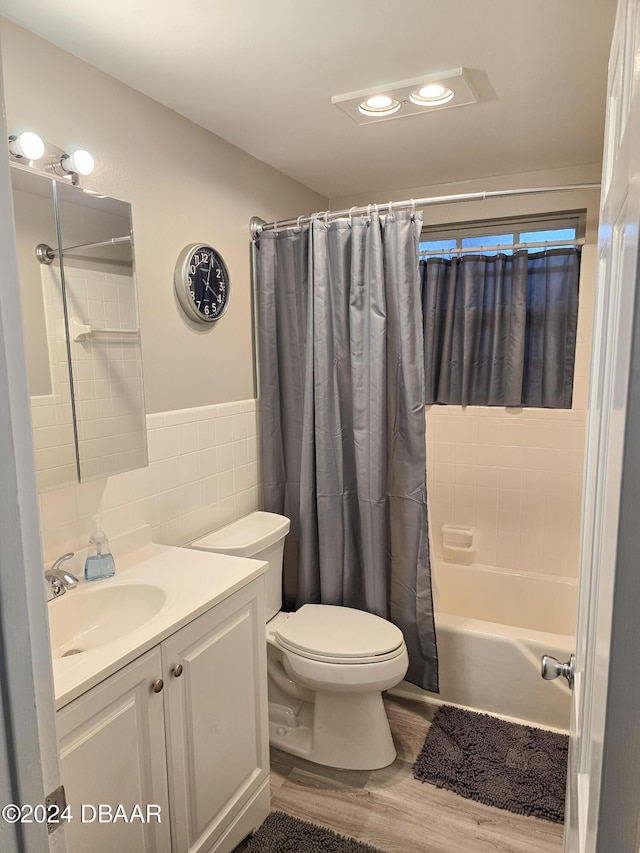 full bathroom with shower / bathtub combination with curtain, toilet, vanity, tile walls, and hardwood / wood-style flooring