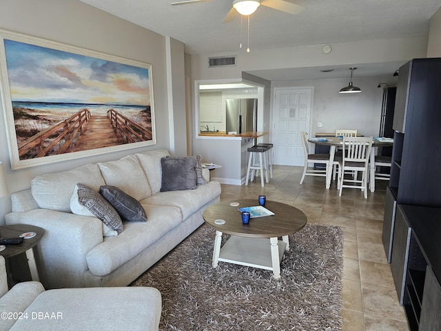 tiled living room featuring ceiling fan