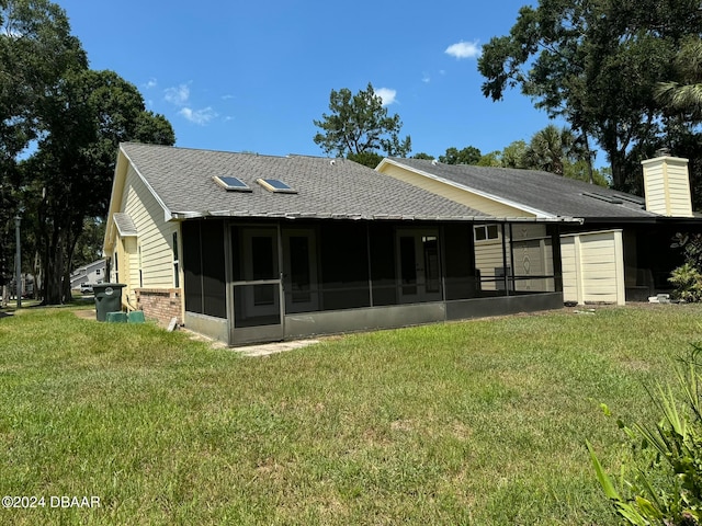 back of house featuring a yard and a sunroom