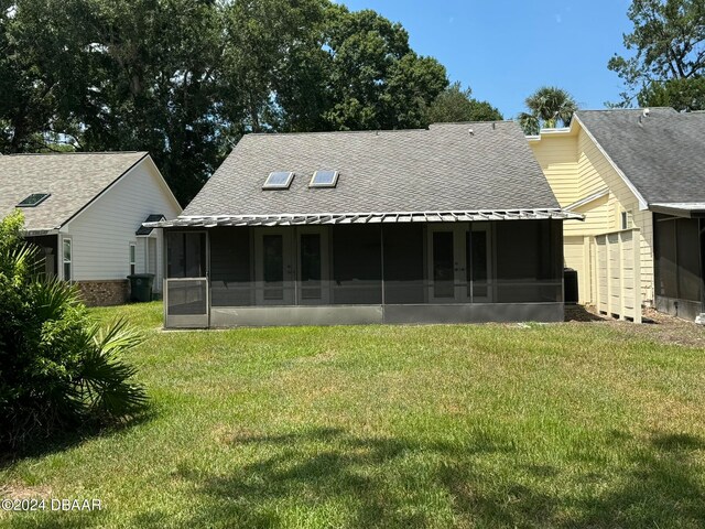 rear view of house with a sunroom and a lawn