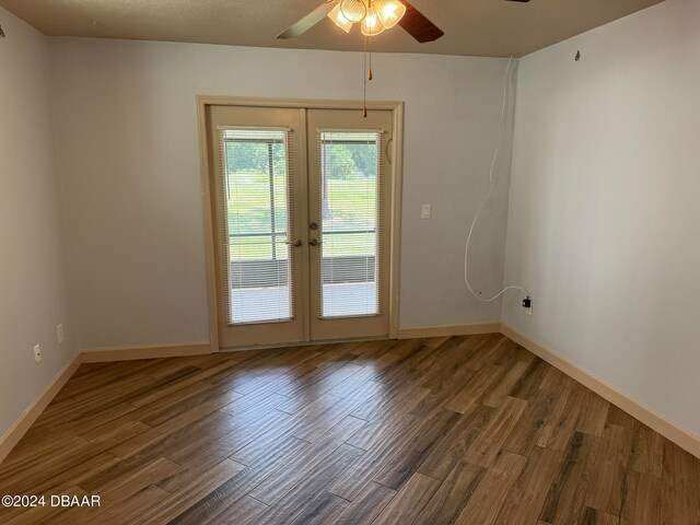 unfurnished room featuring ceiling fan, dark hardwood / wood-style flooring, and french doors