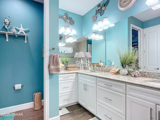 full bathroom with double vanity, a sink, and wood tiled floor