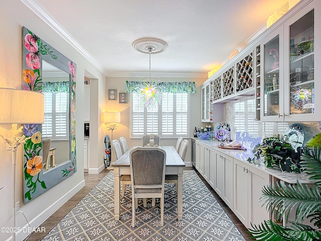 dining area with dark wood-style floors, baseboards, and crown molding