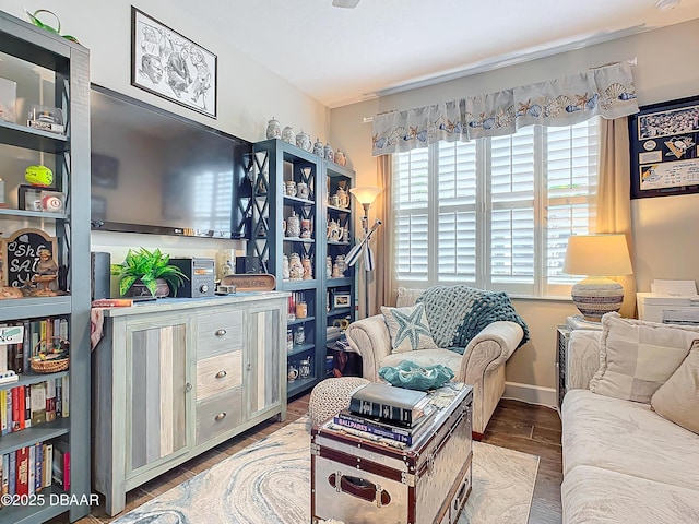 living area featuring baseboards and wood finished floors