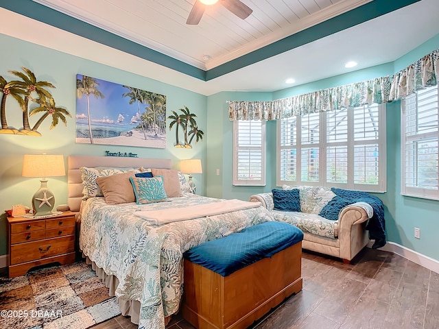 bedroom with wood finished floors, a ceiling fan, baseboards, ornamental molding, and a raised ceiling