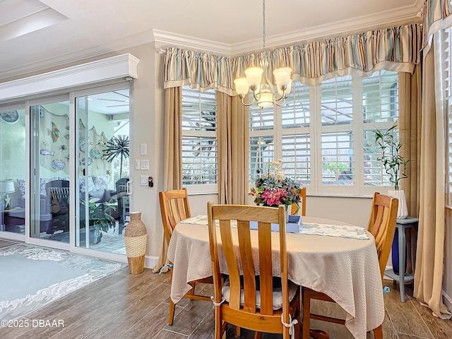 dining area featuring a notable chandelier, crown molding, and wood finished floors