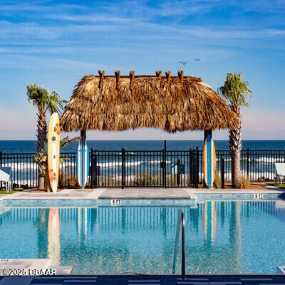 view of swimming pool with a gazebo, a water view, and fence