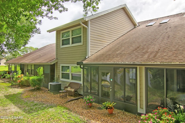 back of property featuring central air condition unit and a sunroom