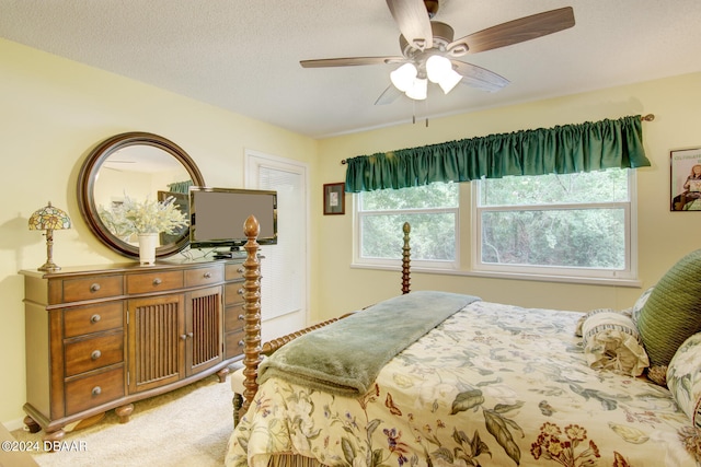 carpeted bedroom with ceiling fan and a textured ceiling