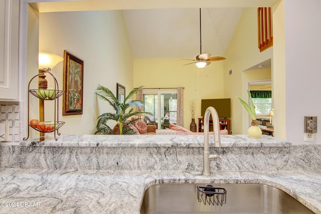 2051 Cornell Pl Unit 26, Port Orange, FL 32128 - kitchen featuring high vaulted ceiling, ceiling fan, light stone counters, and open floor plan
