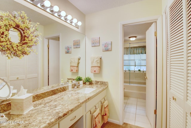 bathroom with a textured ceiling, tile patterned flooring, and vanity