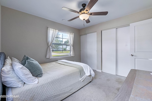 bedroom featuring multiple closets, carpet flooring, and ceiling fan