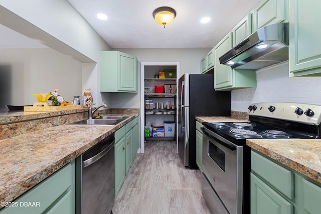 kitchen with stainless steel appliances, sink, light hardwood / wood-style flooring, and green cabinetry