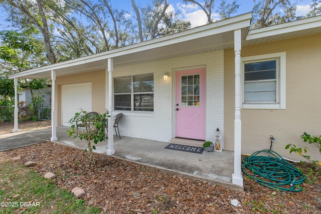 entrance to property with a garage and a porch