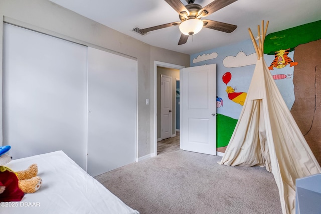 carpeted bedroom featuring ceiling fan and a closet