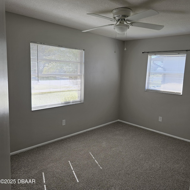 carpeted empty room featuring ceiling fan, a textured ceiling, and a wealth of natural light