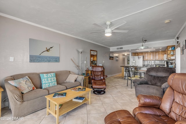 living room with ceiling fan, a textured ceiling, light tile patterned floors, and ornamental molding