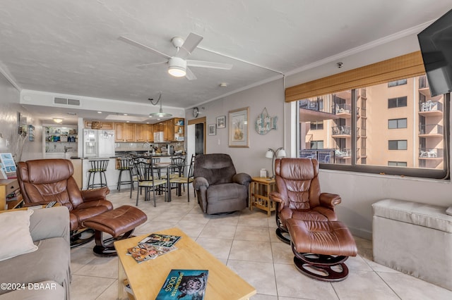 tiled living room featuring ornamental molding and ceiling fan