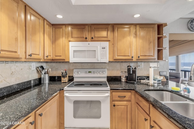 kitchen with dark stone counters, sink, white appliances, and backsplash