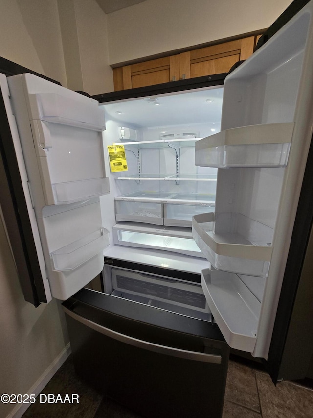 2800 N Atlantic Ave Unit 101, Daytona Beach, FL 32118 - kitchen view of brown cabinetry, baseboards, and freestanding refrigerator