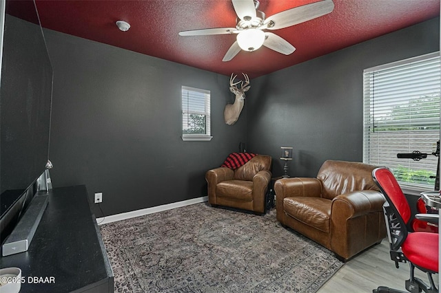 sitting room featuring ceiling fan, a textured ceiling, and light wood-type flooring