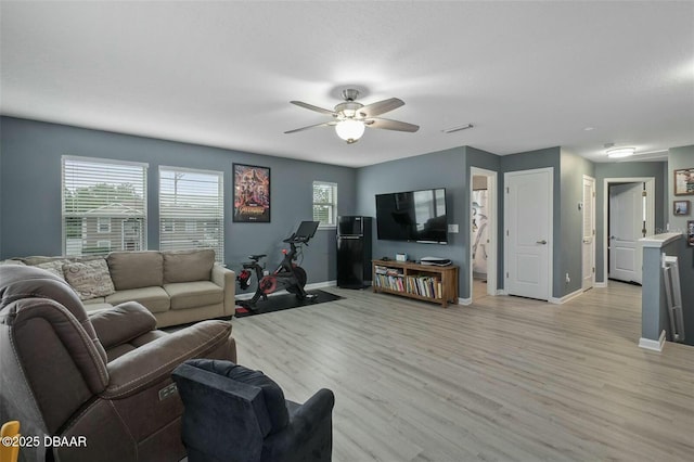 living room featuring plenty of natural light, light hardwood / wood-style floors, and ceiling fan