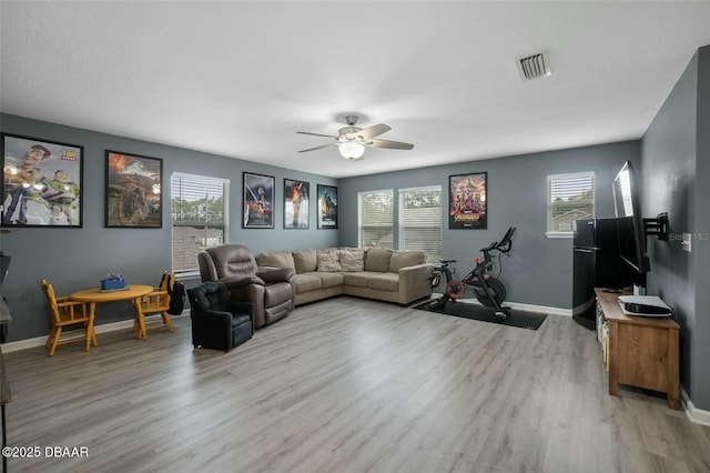 living room featuring light hardwood / wood-style floors and ceiling fan