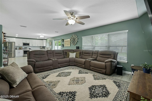 living room featuring light hardwood / wood-style floors and ceiling fan