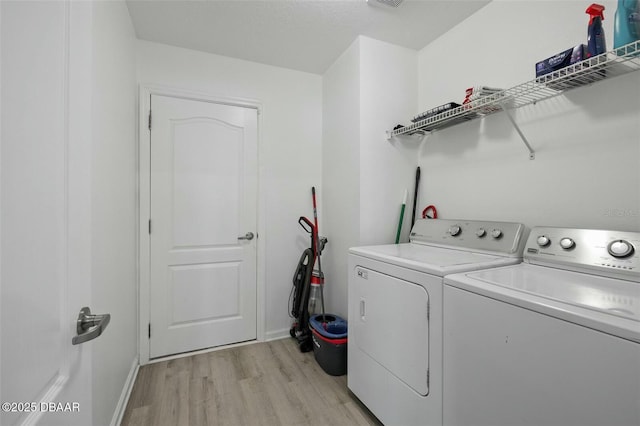 washroom with separate washer and dryer and light hardwood / wood-style floors