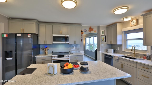 kitchen featuring tasteful backsplash, sink, gray cabinets, and stainless steel appliances