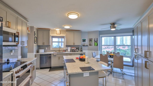 kitchen with tasteful backsplash, stainless steel appliances, sink, and light tile patterned floors