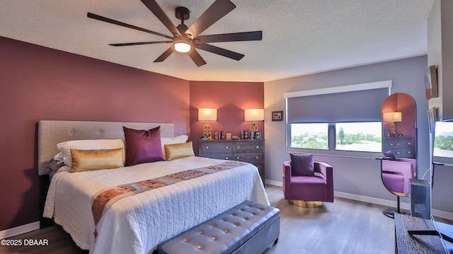 bedroom with hardwood / wood-style floors, a textured ceiling, and ceiling fan