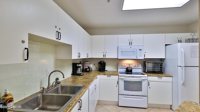 kitchen with light tile patterned flooring, sink, tasteful backsplash, white appliances, and white cabinets