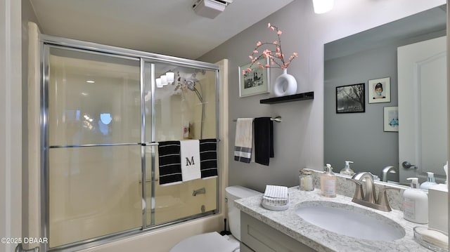 full bathroom with enclosed tub / shower combo, vanity, and toilet