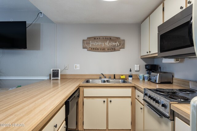 kitchen with stainless steel appliances, white cabinetry, and sink