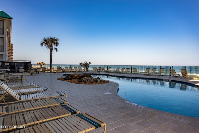 view of pool with a patio and a water view