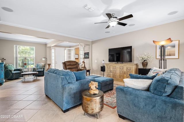 living room featuring crown molding, light tile patterned flooring, ceiling fan, and ornate columns