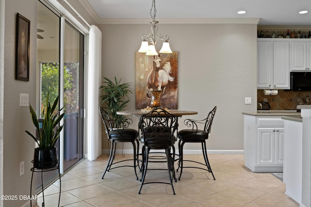 tiled dining space with ornamental molding and an inviting chandelier