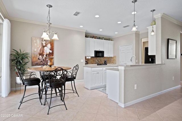 kitchen featuring tasteful backsplash, black appliances, light tile patterned floors, kitchen peninsula, and white cabinets